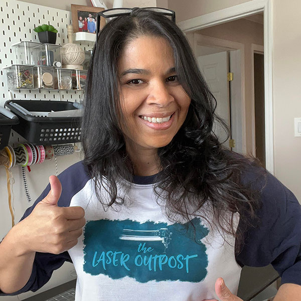 photo of Liz in her craft room, flashing a smile and giving a thumbs up.