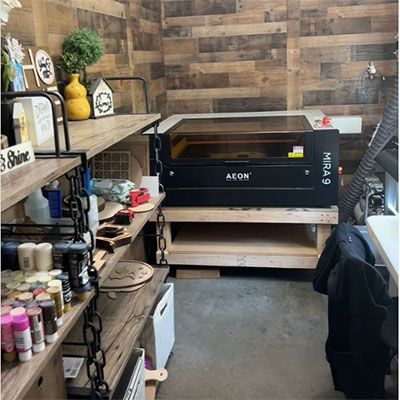 Aeon MIRA Pro Laser in a home office with lots of shelves and wood paneling