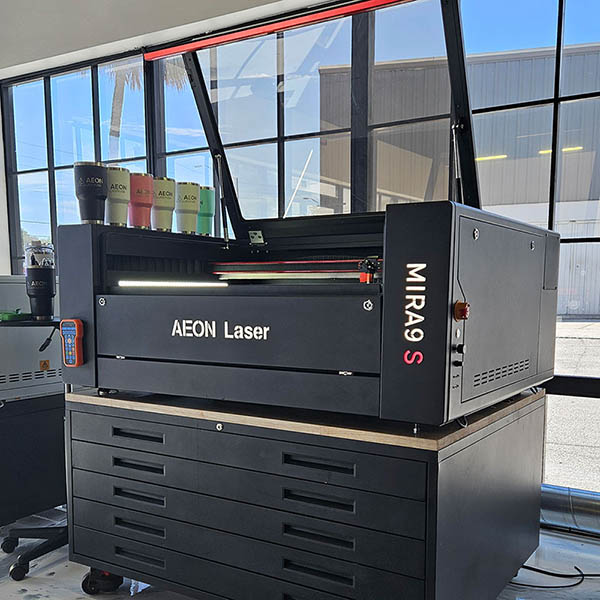 Product specialist and person looking at an Aeon laser together in the Aeon Laser USA showroom