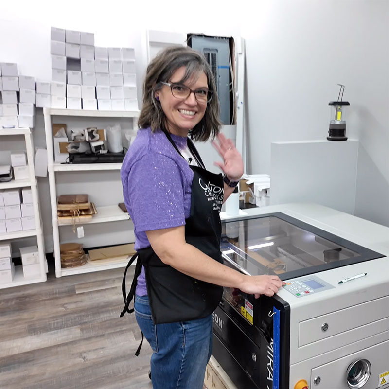 photo of Suzie Quinton standing over her laser smiling