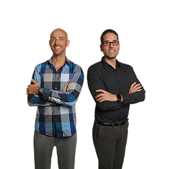 Danny and Lek standing side by side smiling, with their arms folded